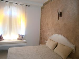 Un dormitorio con una cama y una ventana con una cruz en Tataouineranch, en Tataouine