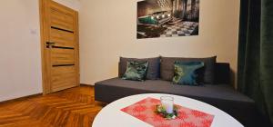 una sala de estar con un sofá y una mesa en Apartment on the San River, en Przemyśl