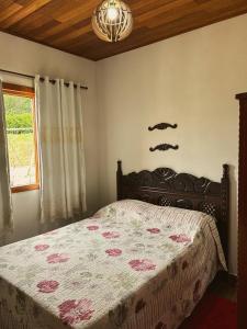 um quarto com uma cama e uma janela em Chalé Casa em Vargem Alta em Vargem Alta