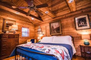 een slaapkamer met een bed in een houten hut bij The Claiborne Bed and Breakfast in Rocky Mount
