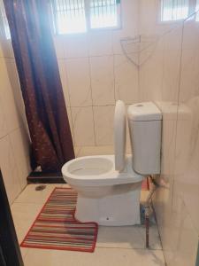 a bathroom with a toilet with a window and a rug at Double bed in Nadi