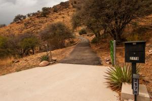 a dirt road with a sign on the side of a hill at Galeria Viviente Eco Casita in Bisbee +10 photos