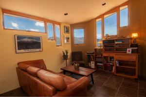 a living room with a leather couch and a table at Galeria Viviente Eco Casita in Bisbee