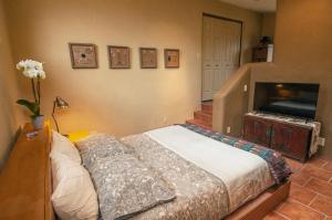a bedroom with a bed and a flat screen tv at Galeria Viviente Eco Casita in Bisbee