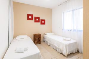 2 camas individuais num quarto com uma janela em Oceanview A102 - PÉ NA ÁREA - perto do centro, 2 dormitórios, piscina, cozinha, 116m2 em Cumbuco