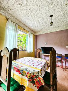sypialnia z łóżkiem, stołem i oknem w obiekcie Sítio do Sossego w mieście Cachoeiras de Macacu