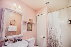 een badkamer met een wastafel, een toilet en een spiegel bij The Claiborne Bed and Breakfast in Rocky Mount