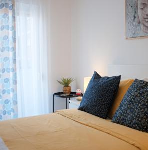 Un dormitorio con una cama con almohadas azules y una mesa. en Just4u Apartment, en Almada
