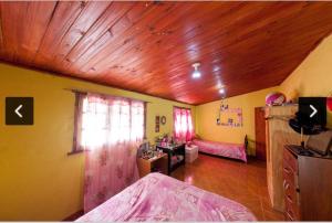 Cette chambre comprend un lit et un plafond en bois. dans l'établissement Casita en lozano, à Lozano