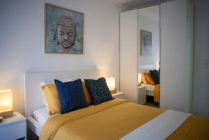 Just4u Apartment في ألمادا: غرفة نوم مع سرير مزدوج كبير مع وسائد زرقاء وصفراء