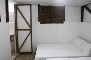 a room with a bed and a wooden door at Sapiens house "cabaña del Río" in Cali