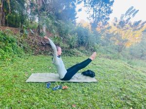 a man doing a yoga pose on the grass at orchid villa in Ella