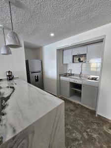 a kitchen with a sink and a refrigerator at Apartamento Torres gemelas in Acapulco