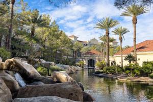 un complexe avec un étang, des palmiers et des bâtiments dans l'établissement JW Marriott Las Vegas Resort and Spa, à Las Vegas