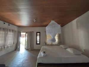um quarto com uma cama grande e um tecto em madeira em Taipu In House em Maraú
