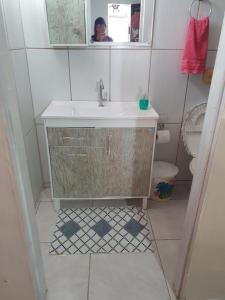 y baño con lavabo y espejo. en Casa Dos Praieiros, en Jaguaruna