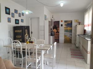 a kitchen and dining room with a table and chairs at Casa Dos Praieiros in Jaguaruna