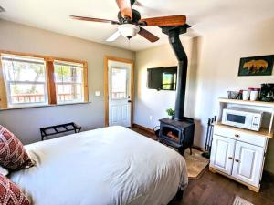 een slaapkamer met een bed en een houtkachel bij #3 Howling Wolf's Lair - Cabin W/Fireplace & Views in Santa Ysabel