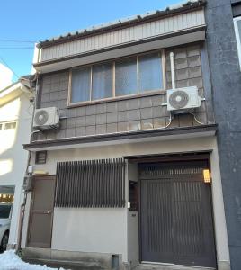 un edificio con dos aparatos de aire acondicionado a un lado en 福井駅から徒歩2分の1棟貸切民泊 最低限 en Fukui