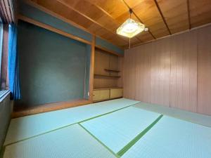 Habitación vacía con ventana grande en una habitación en 福井駅から徒歩2分の1棟貸切民泊 最低限 en Fukui