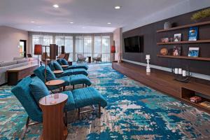 a living room with blue chairs and a large rug at Courtyard by Marriott San Antonio North Stone Oak At Legacy in San Antonio
