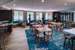 a restaurant with tables and chairs and a couch at Courtyard by Marriott San Antonio North Stone Oak At Legacy in San Antonio