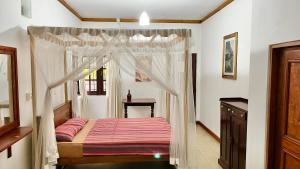 een slaapkamer met een hemelbed bij Pearl House in Kandy
