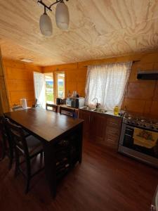 a kitchen with a wooden table and a stove at Quilquico spa in Quilquico