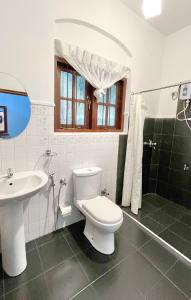 een badkamer met een wit toilet en een wastafel bij Pearl House in Kandy