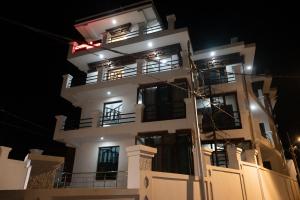 a tall white building with windows at night at Banaras Residency in Leh