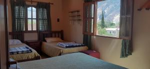 una habitación con tres camas y una ventana en Maimará Jujuy, en Maimará