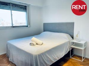 1 dormitorio con 1 cama y un círculo rojo con una foto en Rent Membrillar en Buenos Aires