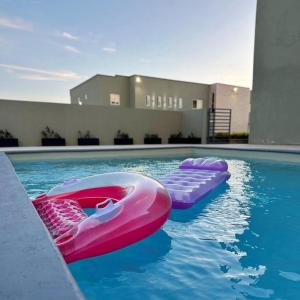 a pool with two inflatables in the water at Serenity Condo in Piarco