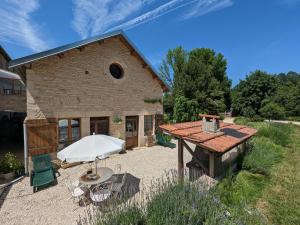 a large stone building with a table and chairs at Gîte familial 2 chambres avec piscine, animaux, et vaste terrain à Forcey - FR-1-611-75 in Forcey