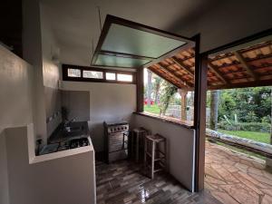 cocina con fregadero, fogones y ventana en Natural Forest en Praia do Rosa