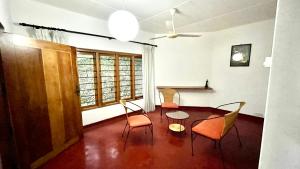 een eetkamer met een tafel en stoelen in een kamer bij Pearl House in Kandy