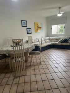 un soggiorno con divano, tavolo e sedie di Cond. Clube Riviera S. Lourenço a Bertioga