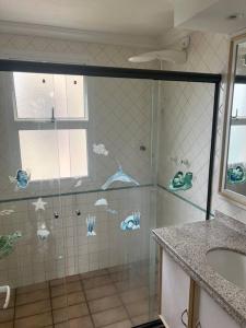 bagno con doccia con farfalle sul muro di Cond. Clube Riviera S. Lourenço a Bertioga