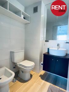 y baño con aseo blanco y lavamanos. en Rent Juan B Justo en Buenos Aires