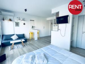 Habitación blanca con cama y sofá en Rent Juan B Justo en Buenos Aires