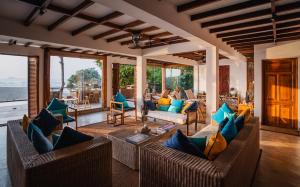 a living room with couches and chairs and windows at C Beyond Nilaveli in Nilaveli