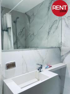 Baño blanco con lavabo y espejo en Rent Vera en Buenos Aires