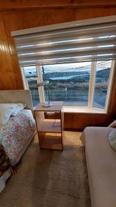 1 dormitorio con 1 cama y 1 mesa con lámpara en Depto. Altos de Tenglo, en Puerto Montt