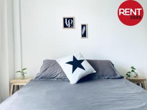 Una cama con una almohada de estrella azul. en Rent Balbin en Buenos Aires