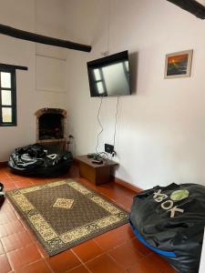 a living room with a fireplace and a tv on the wall at Casa Villa Ramos in Villa de Leyva