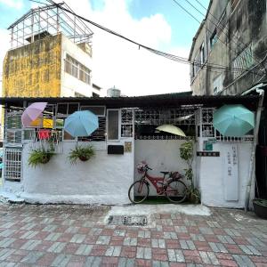 una bicicleta estacionada frente a un edificio con sombrillas en Huabing, en Tainan