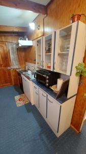 a kitchen with white cabinets and a black counter top at Depto. Altos de Tenglo in Puerto Montt