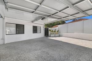 uma garagem vazia com um edifício branco em 5BR Mermaid Waters Luxury Home em Gold Coast