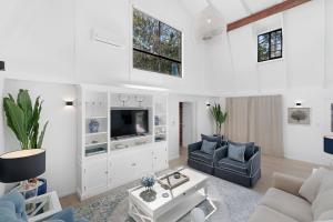 sala de estar con sofá y TV en 5BR Mermaid Waters Luxury Home, en Gold Coast