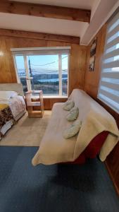 a bedroom with a bed with pillows and a window at Depto. Altos de Tenglo in Puerto Montt